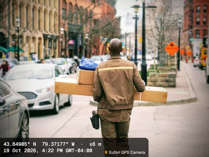 Courier carrying parcels down a city street, with the Minimal stamp: coordinates with ±6 m accuracy and the delivery time, Toronto